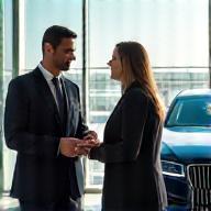 Guest being greeted at airport in luxury car
